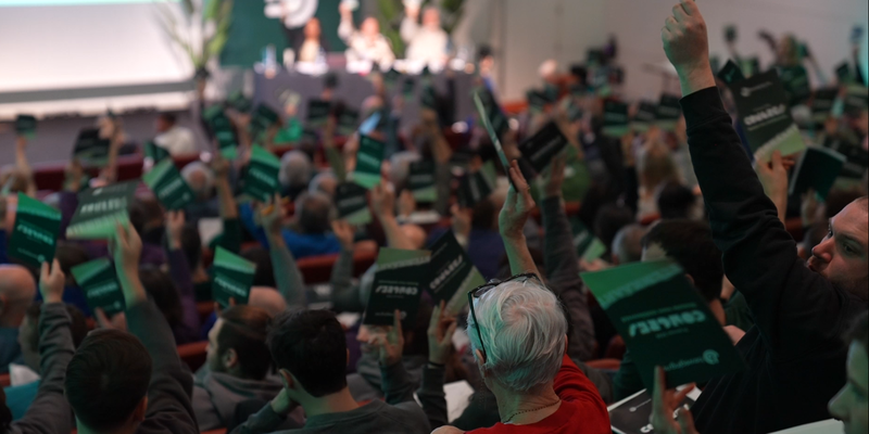Volle zaal tijdens congres van beweging.net, mensen zijn aan het stemmen.