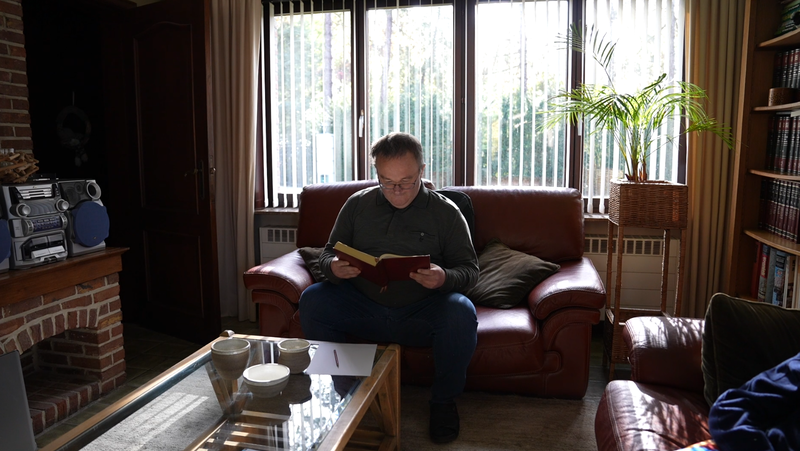 Man zit in zetel en leest een boek.