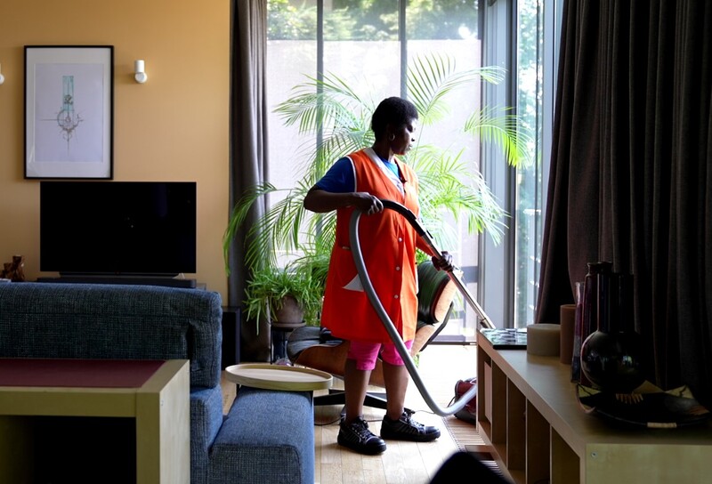 Poetshulp Rose stofzuigt de woonkamer.