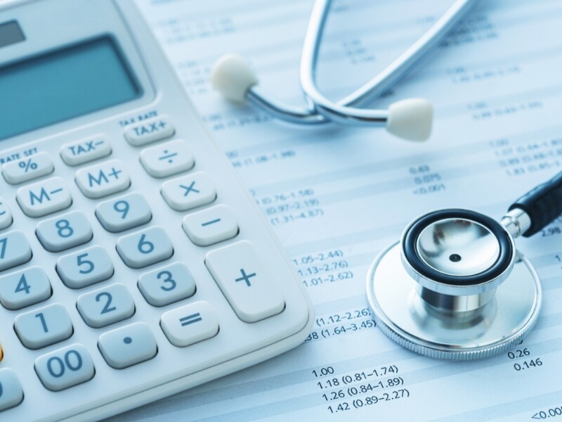 Rekenmachine en stethoscoop op ziekenhuisfactuur
